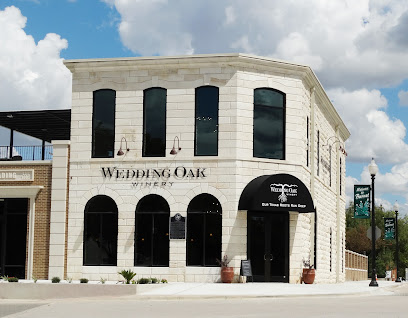 Exterior of Wedding Oak Winery, a two-story corner building with a limestone facade and a black entrance awning.